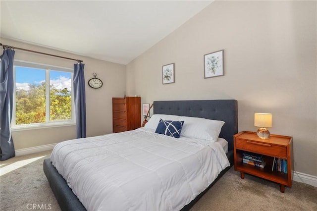 bedroom with lofted ceiling, light carpet, and baseboards