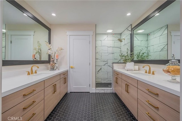 full bath featuring recessed lighting, two vanities, a sink, and a marble finish shower