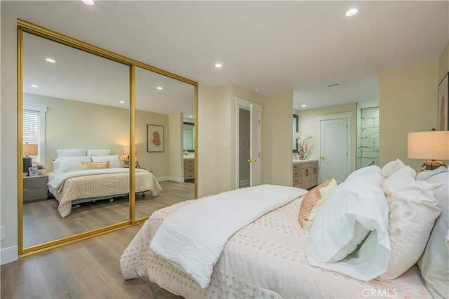 bedroom with light wood-type flooring, baseboards, a closet, and recessed lighting