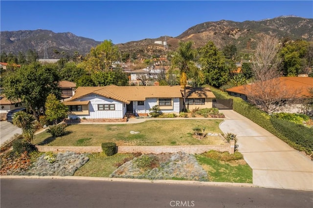 view of front of home with a front yard and a mountain view