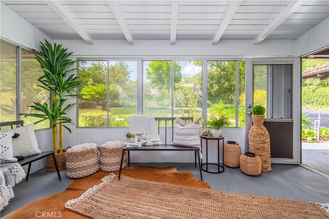 sunroom / solarium featuring beamed ceiling