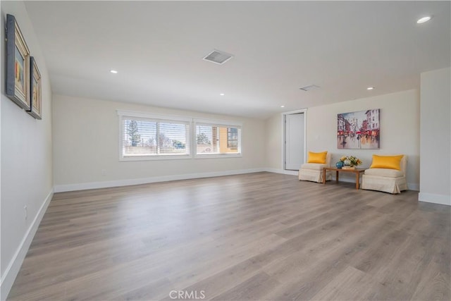 unfurnished room with baseboards, light wood-type flooring, visible vents, and recessed lighting