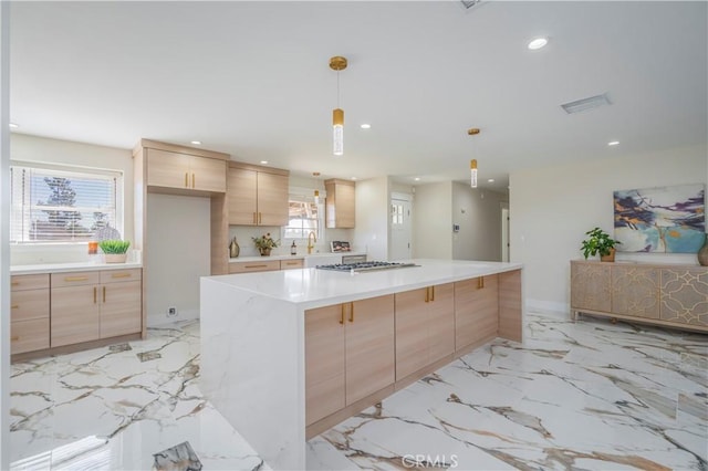 kitchen with pendant lighting, recessed lighting, light countertops, light brown cabinets, and plenty of natural light