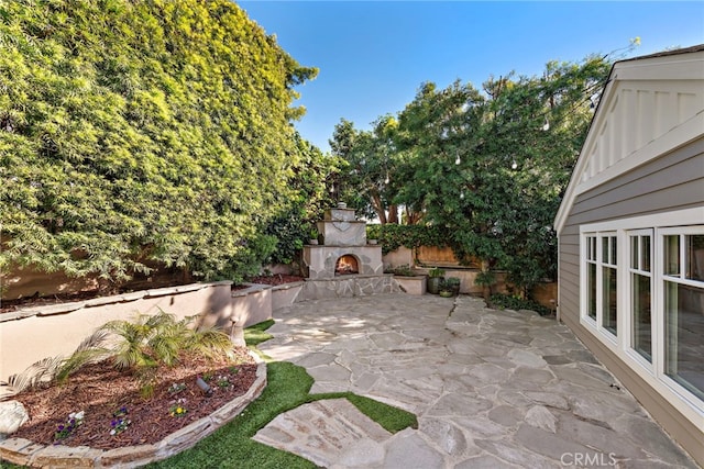 view of patio / terrace featuring an outdoor stone fireplace