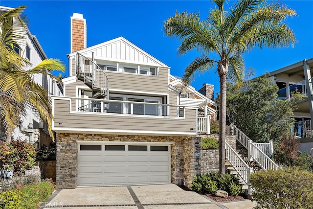 1020 La Mirada St, Laguna Beach, CA 92651 - view of front of home featuring stone siding, board and batten siding, a chimney, and an attached garage