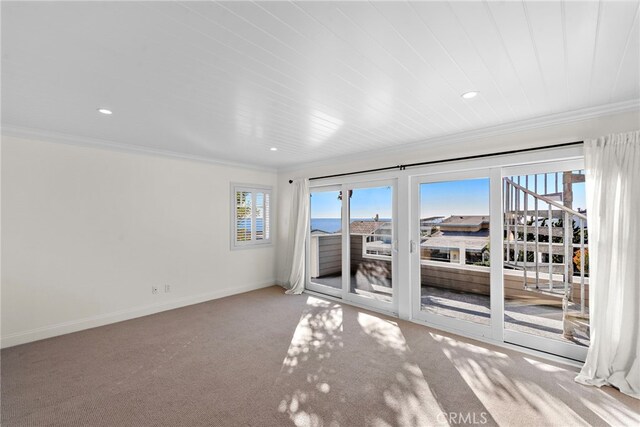 empty room featuring crown molding, recessed lighting, carpet, and baseboards