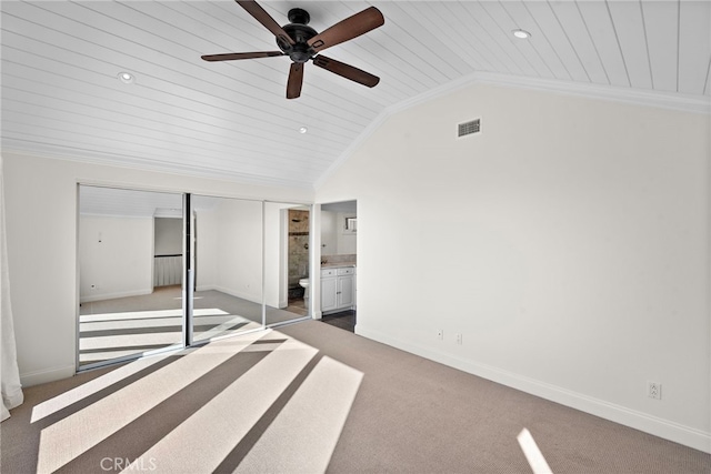 unfurnished bedroom with lofted ceiling, carpet flooring, visible vents, and ornamental molding