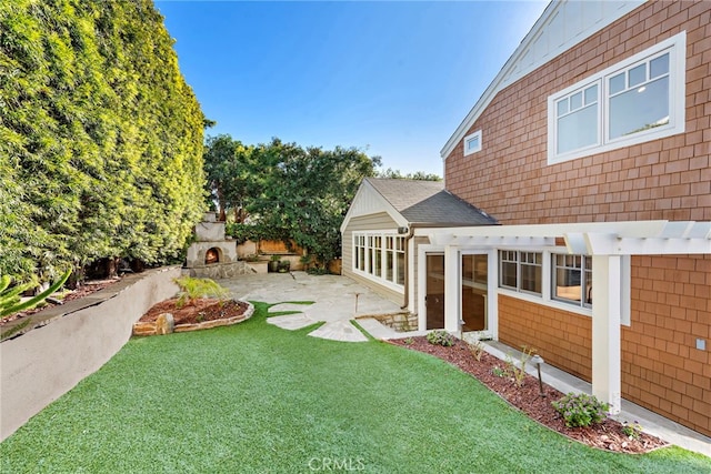 view of yard with a patio and a lit fireplace