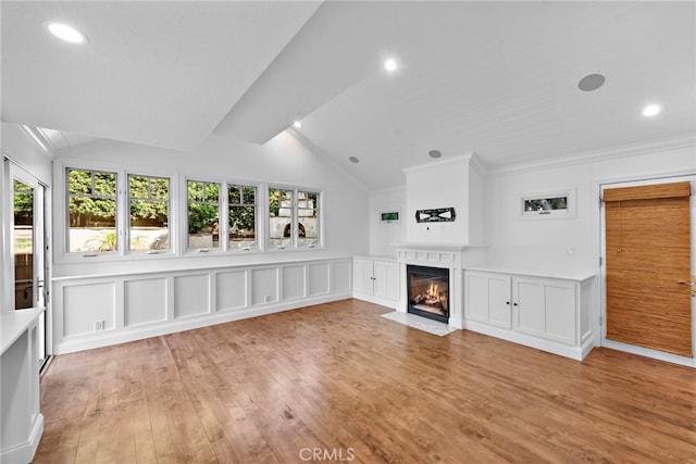 unfurnished living room with lofted ceiling, a healthy amount of sunlight, and a high end fireplace