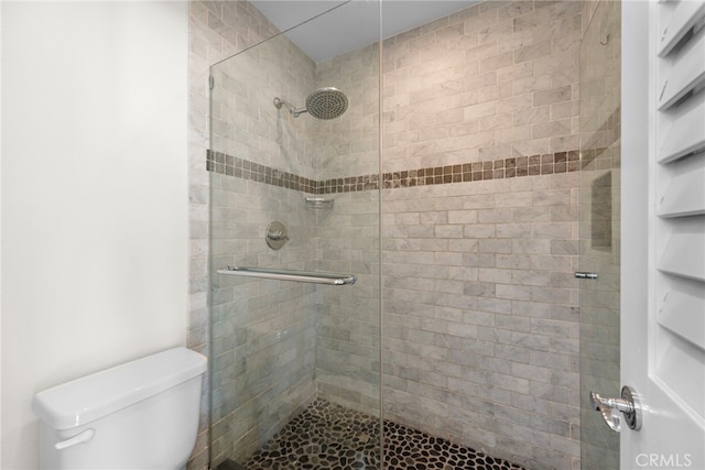 full bathroom with a shower stall and toilet