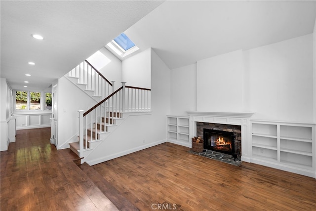 unfurnished living room with recessed lighting, stairway, dark wood-type flooring, and a tile fireplace