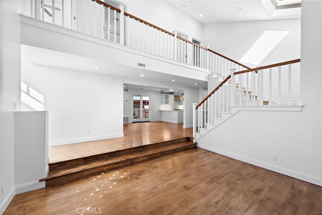 1020 La Mirada St, Laguna Beach, CA 92651 - unfurnished living room with a towering ceiling, wood finished floors, stairs, baseboards, and recessed lighting