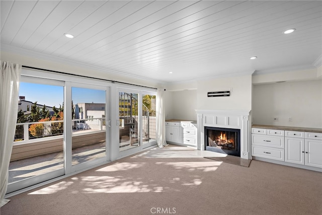 unfurnished living room featuring a fireplace with flush hearth, light colored carpet, recessed lighting, and ornamental molding