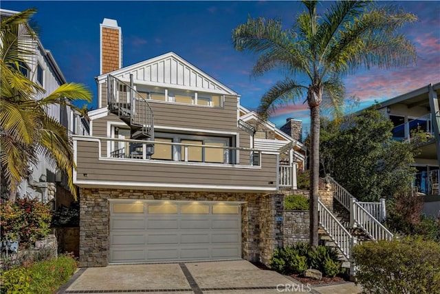 1020 La Mirada St, Laguna Beach, CA 92651 - view of front of home with stone siding, a chimney, board and batten siding, and a garage