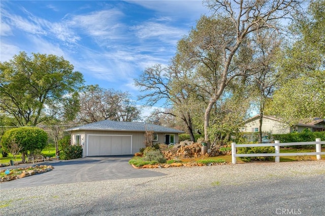 ranch-style home featuring driveway, an attached garage, and fence