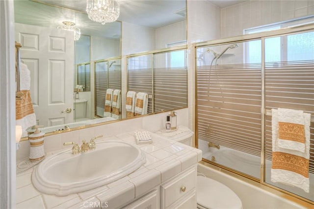 full bath featuring toilet, combined bath / shower with glass door, and vanity