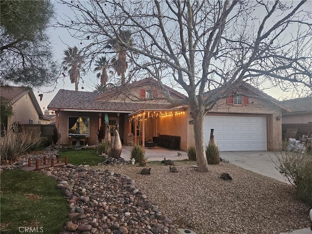 view of front of property featuring an attached garage, concrete driveway, and stucco siding