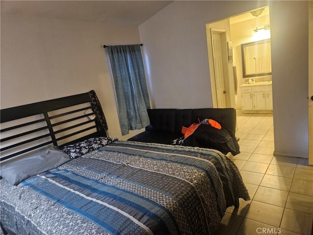 bedroom featuring light tile patterned floors and connected bathroom