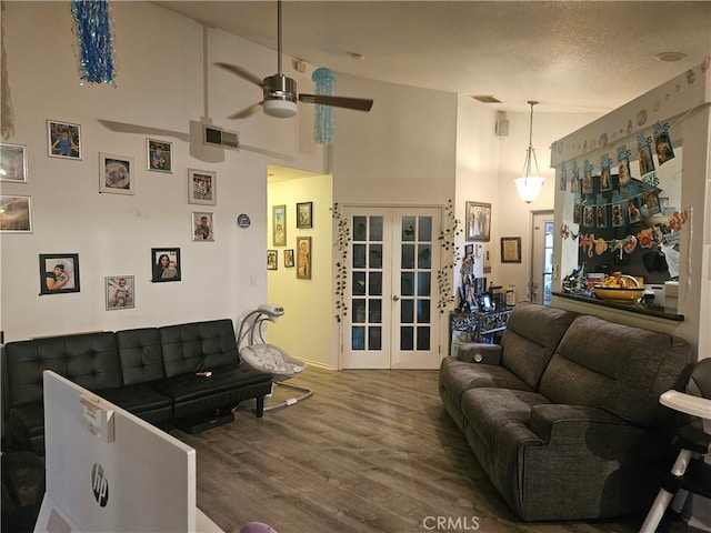 living area featuring french doors, visible vents, ceiling fan, wood finished floors, and high vaulted ceiling