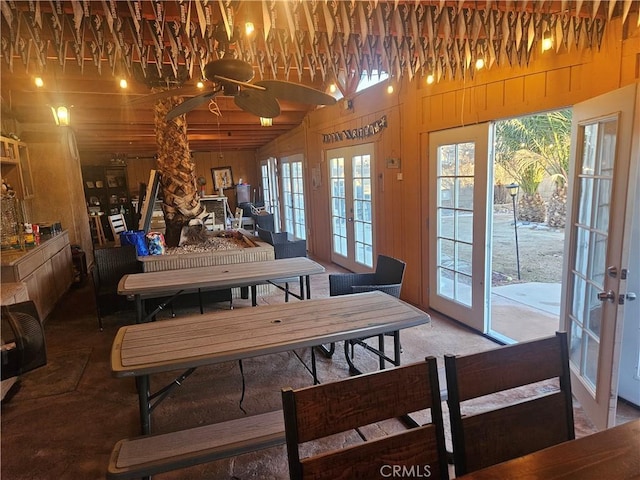 dining room with french doors and wood walls