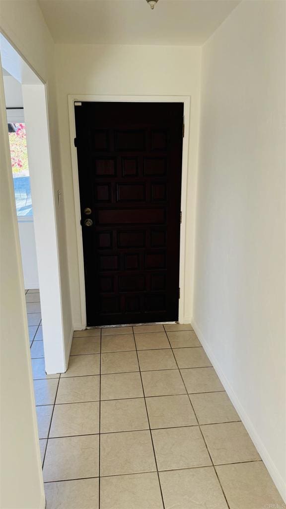 interior space featuring light tile patterned flooring and baseboards