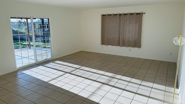 empty room with light tile patterned flooring and baseboards