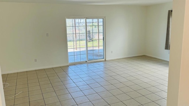 empty room featuring light tile patterned floors and baseboards