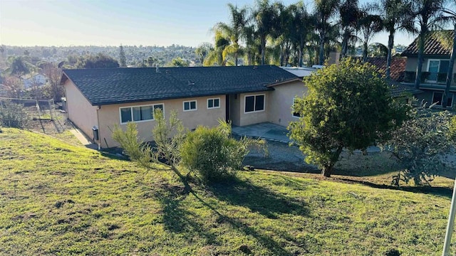 back of house featuring a yard and stucco siding