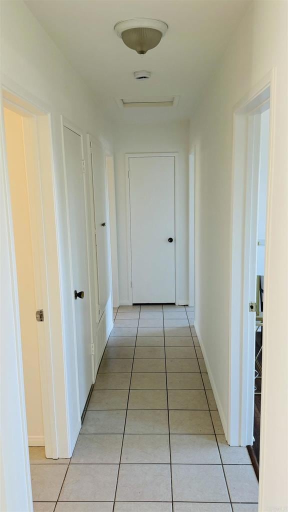 hall with baseboards and light tile patterned flooring