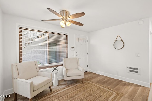 living area with wood finished floors, a wealth of natural light, and baseboards