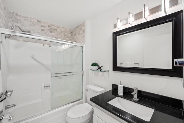 bathroom with shower / bath combination with glass door, vanity, and toilet