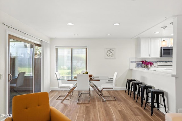 dining room featuring recessed lighting, light wood-style flooring, and baseboards