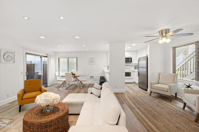 living area with light wood-type flooring, plenty of natural light, and recessed lighting