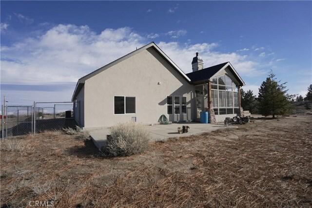 25841 Remington Ct, Tehachapi, CA 93561 - back of property with a patio, a chimney, stucco siding, a sunroom, and fence