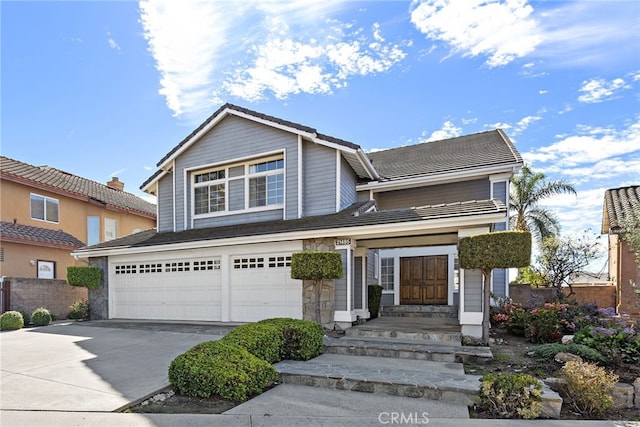 view of front of property with an attached garage, driveway, and a tiled roof