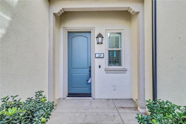 property entrance with stucco siding