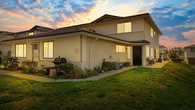 back of house featuring a lawn and a patio area