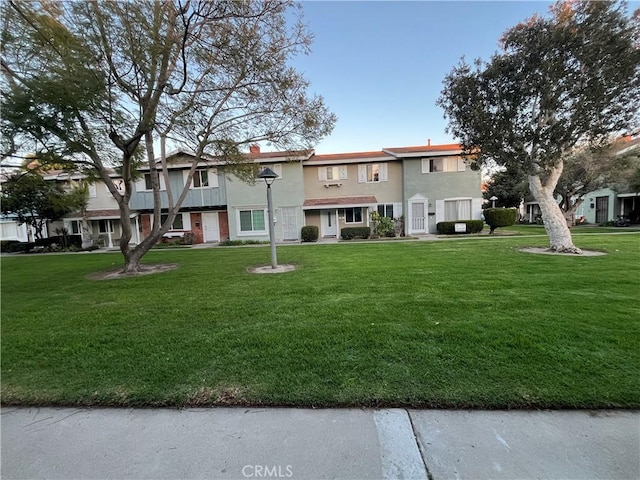 view of front of home with a front yard and stucco siding