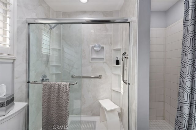 full bathroom with a shower stall and toilet