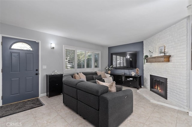 living area with a brick fireplace and baseboards