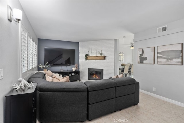 living room featuring a fireplace, light tile patterned floors, visible vents, ceiling fan, and baseboards