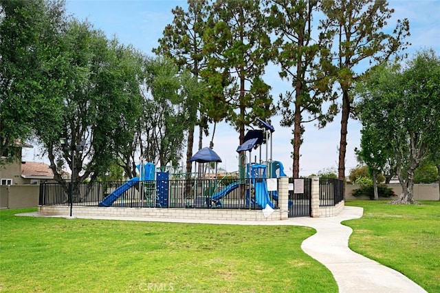 community play area featuring a yard and fence