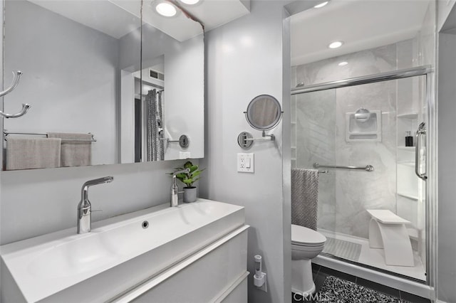 bathroom featuring vanity, a shower stall, toilet, and tile patterned floors