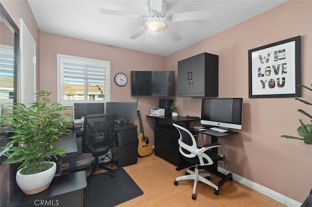 office featuring light wood-style floors, baseboards, and a ceiling fan