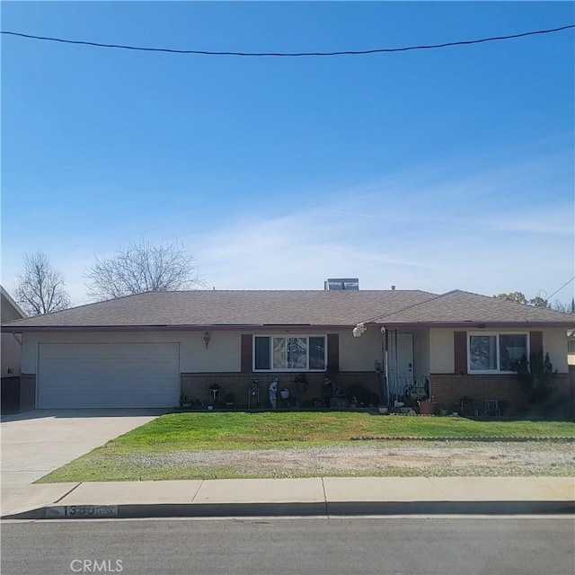 ranch-style home featuring stucco siding, driveway, an attached garage, and a front lawn