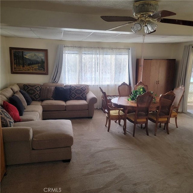 living room featuring a paneled ceiling, light carpet, and ceiling fan