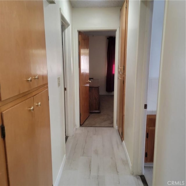 corridor featuring light wood finished floors