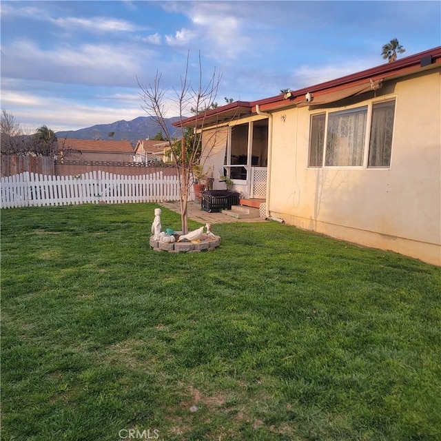 view of yard featuring a mountain view and fence