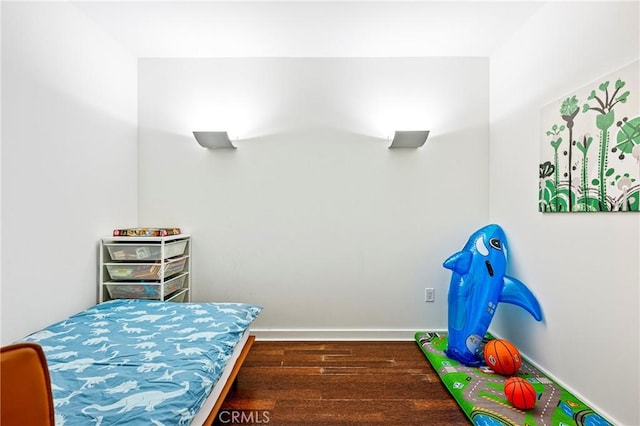 bedroom featuring dark wood-type flooring and baseboards