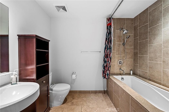 full bath featuring baseboards, visible vents, toilet, tiled shower / bath combo, and a sink